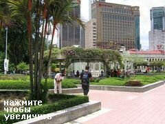 Kuala Lumpur (Malaysia), Menschen verstecken sich im Schatten bei den Springbrunnen